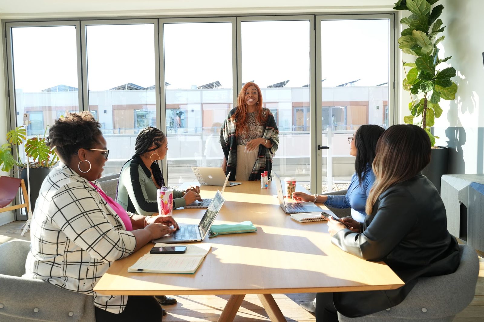 A VTB workshop in session, participants around a sunlit table with Kristen presenting
